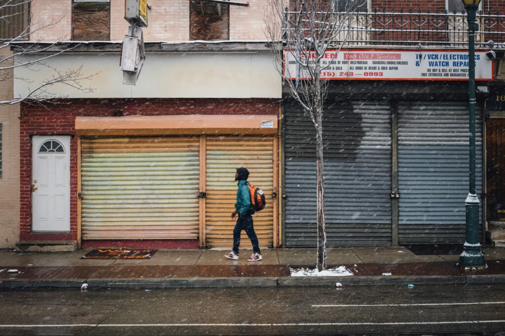 Young man walking down snowy street in Philadelphia.