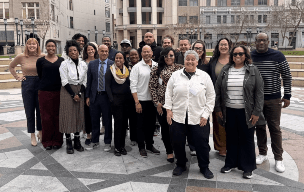 Angie Pabon (front, center), and David Brown (to her right), stand with community foundation representatives from around the country at a convening held in Oakland, CA.